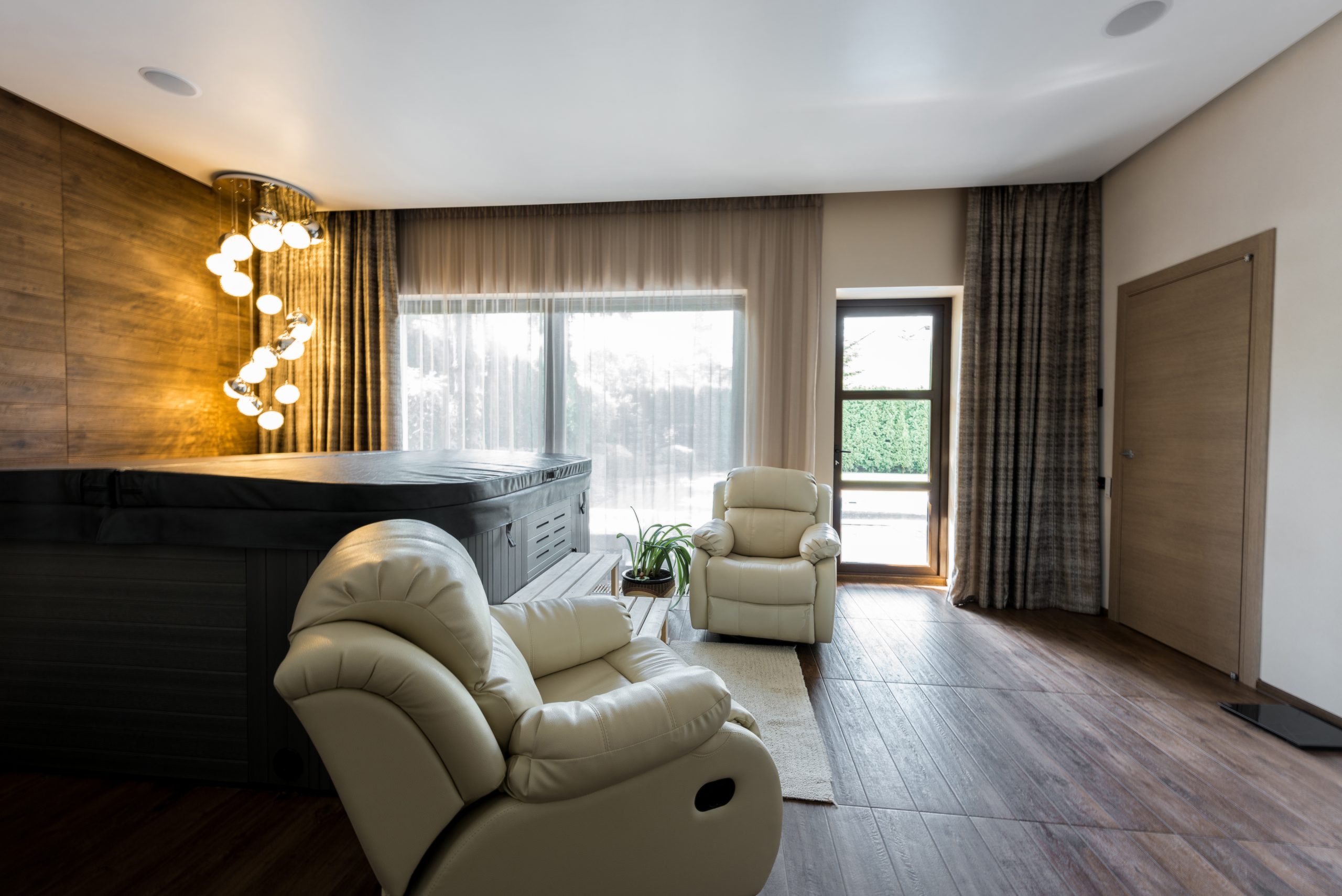 interior of empty modern room with armchairs and closed jacuzzi in spa