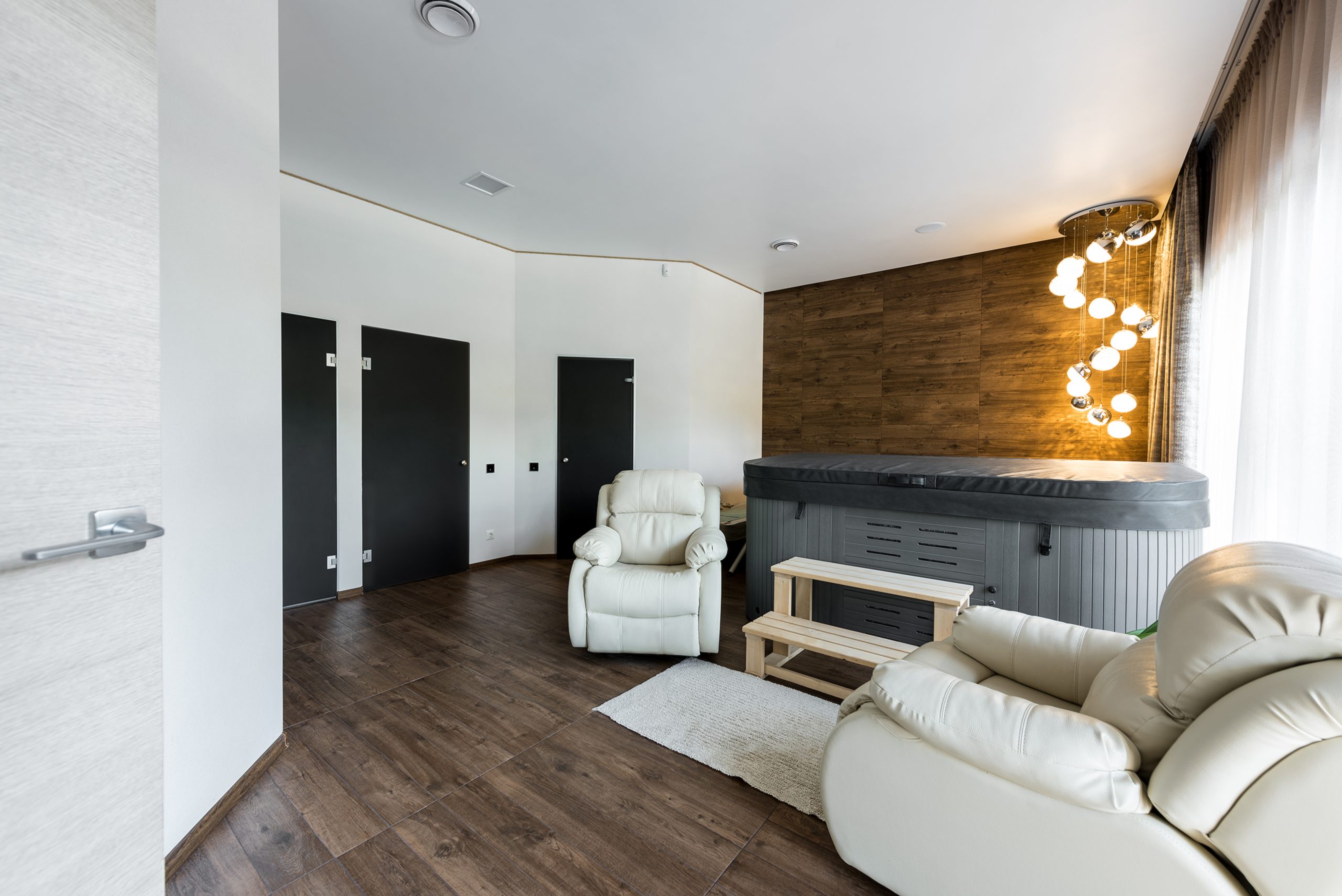 interior view of modern room with armchairs and closed jacuzzi in spa